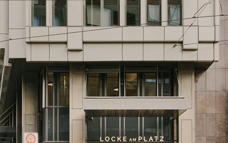 A modern building with a prominent entrance labeled 'LOCKE AM PLATZ.'
