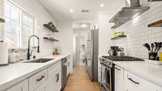 A modern kitchen with white cabinetry, a stainless steel range, and a central island. - Classic Inglewood Gem 3Bed/1Bath w/Jacuzzi (Inglewood)