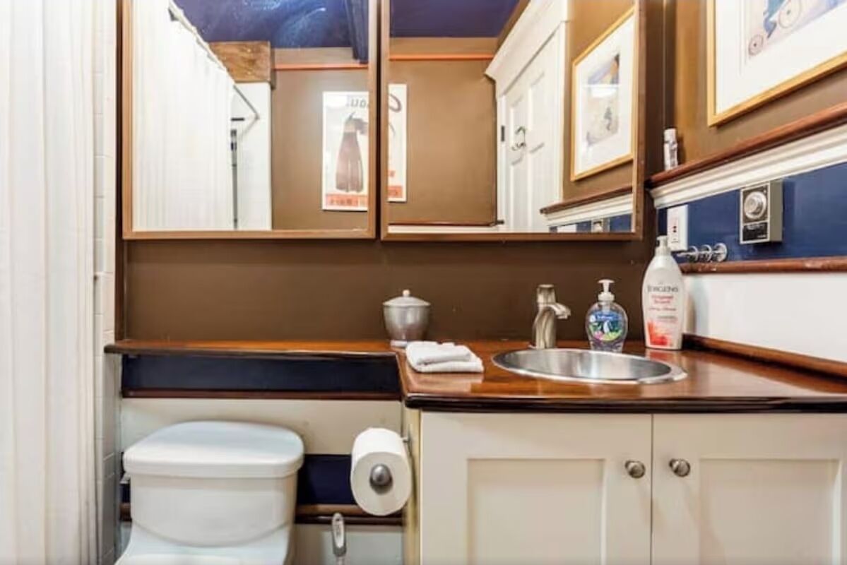 A compact bathroom with a toilet, sink, and storage cabinets.
