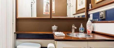 A compact bathroom with a toilet, sink, and storage cabinets.