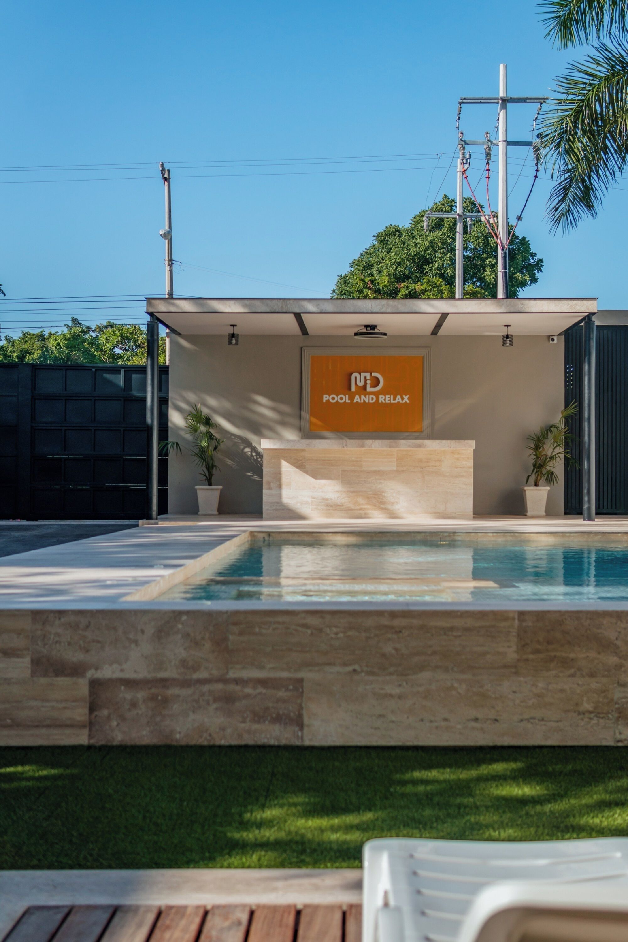 Un área de piscina moderna con un letrero que dice 'MD POOL AND RELAX'.