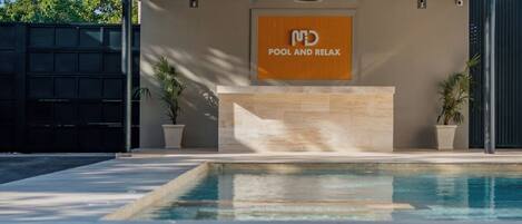 Un área de piscina moderna con un letrero que dice 'MD POOL AND RELAX'.