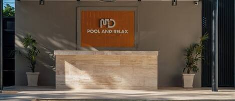 Un área de piscina moderna con un cartel que dice 'ND POOL AND RELAX'.