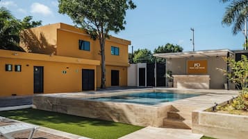 Un bâtiment moderne doté d’une piscine, d’une terrasse en bois et d’une pancarte indiquant « PISCINE ET SALLE DE BAINS ».
