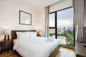 Relax in a spacious room with a large bed, bedside tables, and a city view.