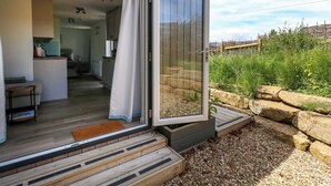 Una casa moderna con puerta de vidrio corredera que da a una sala de estar y cocina.