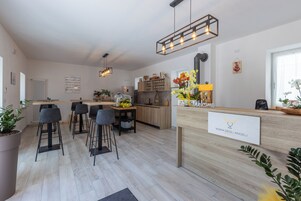 Una cocina moderna con encimera de madera, taburetes de bar y un cartel de bienvenida.