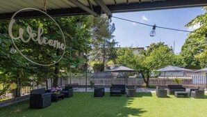 An outdoor patio with a welcome sign, outdoor furniture, and umbrellas. - Vigna degli Angeli (Ragogna)