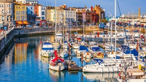 A marina with numerous boats docked, surrounded by colorful buildings. - Cosy Coach House Garden Apt by the Sea Res Parking (Broadstairs)