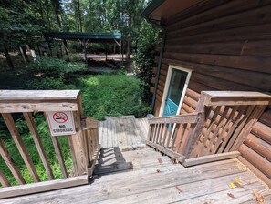 A wooden cabin with a porch, a 'NO SMOKING' sign, and a green door. - Cozy Elegant Cabin in the heart of Snellville forest (Snellville)