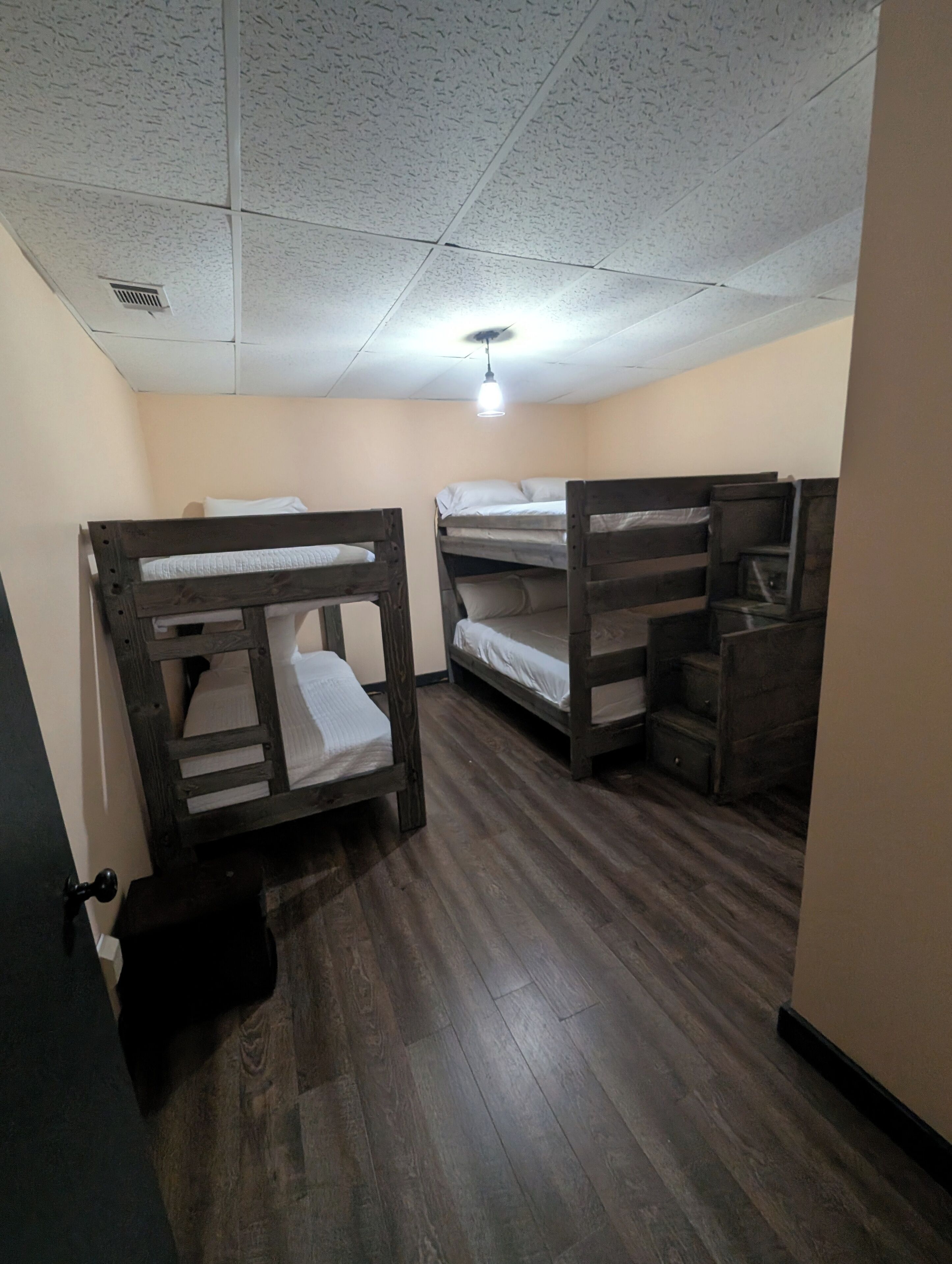 A room with bunk beds, a ceiling fan, and a light fixture.