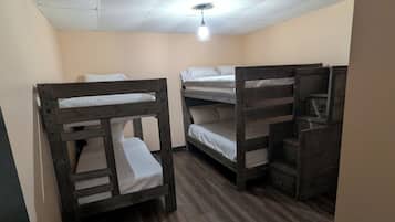 A room with bunk beds, a ceiling fan, and a light fixture.