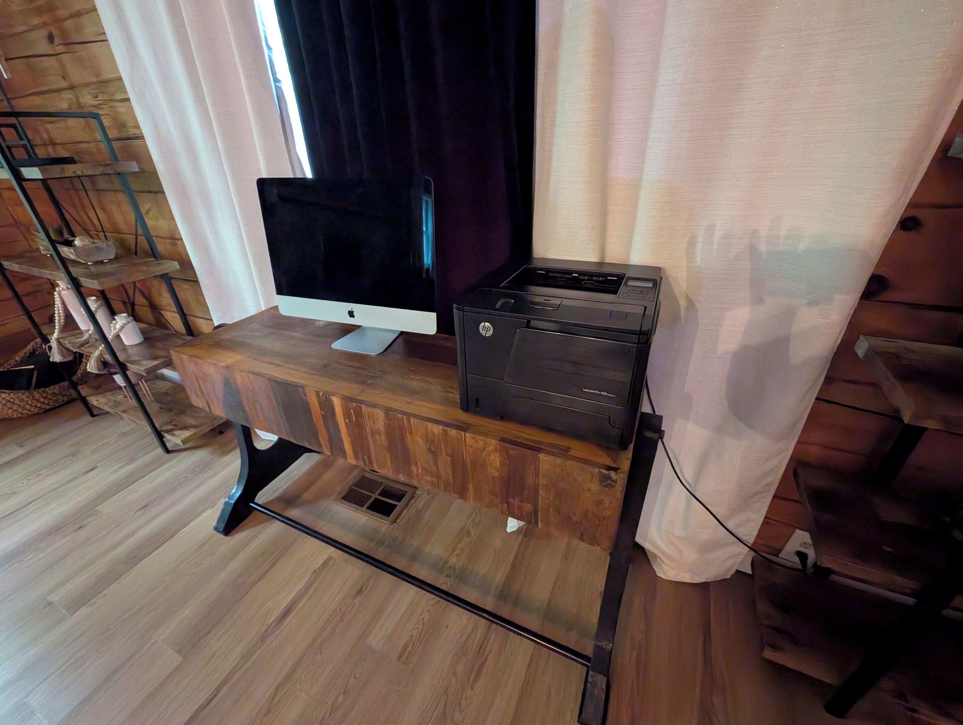 A wooden desk with a flat-screen monitor and a printer.