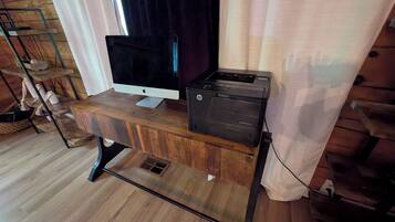 A wooden desk with a flat-screen monitor and a printer.