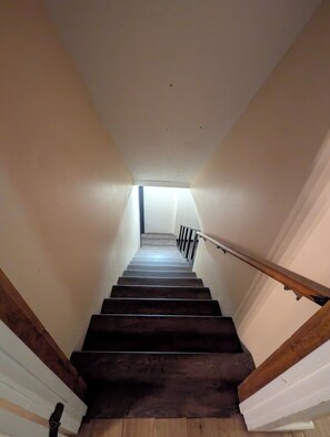 A wooden staircase with a handrail, leading to a landing with a skylight. - Cozy Elegant Cabin in the heart of Snellville forest (Snellville)