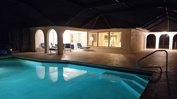 An indoor swimming pool with lounge chairs and a covered seating area. - Ferienvilla Bell Villa Bonita Springs (Bonita Springs)
