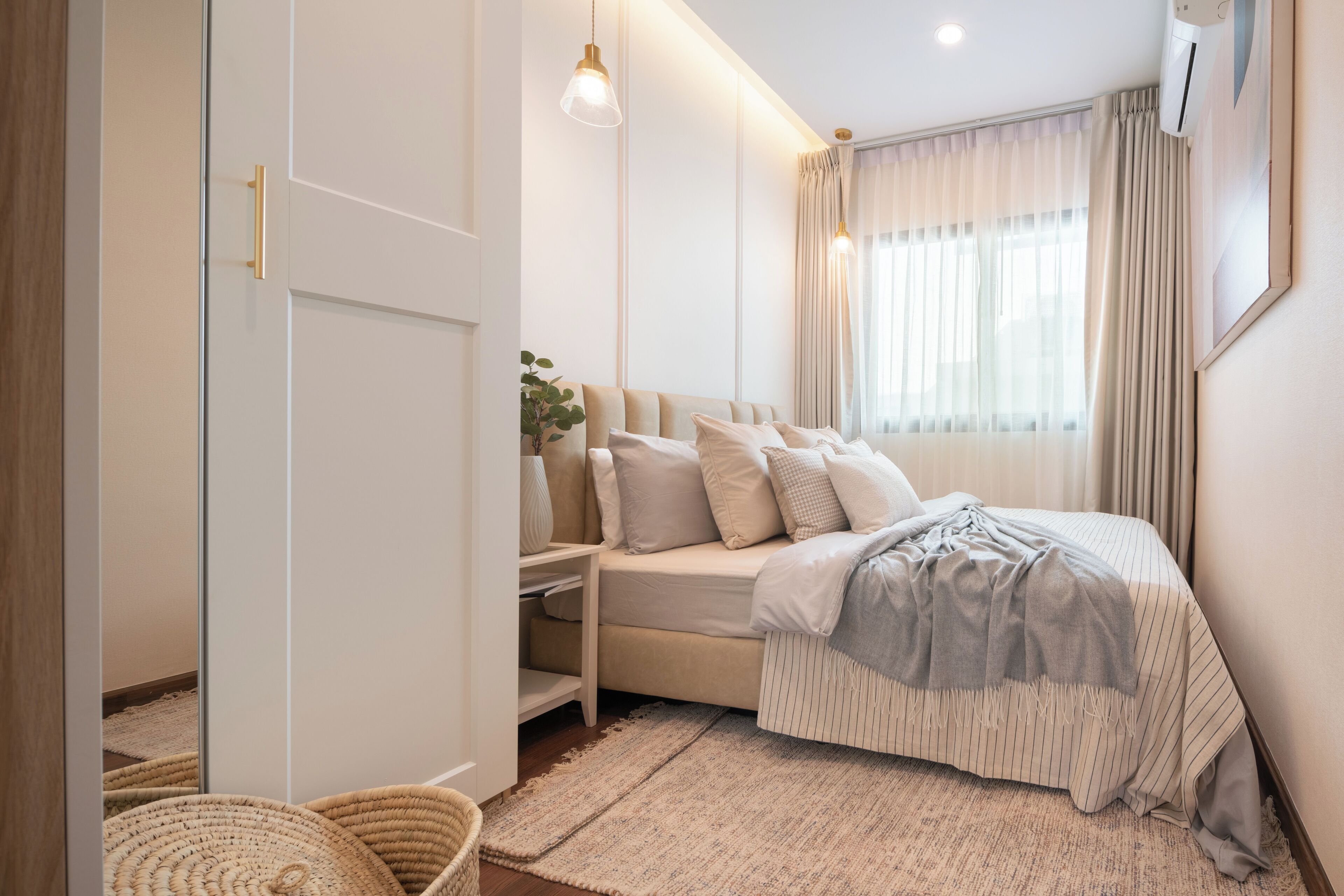 A bedroom with a bed, bedside table, and a window with curtains.