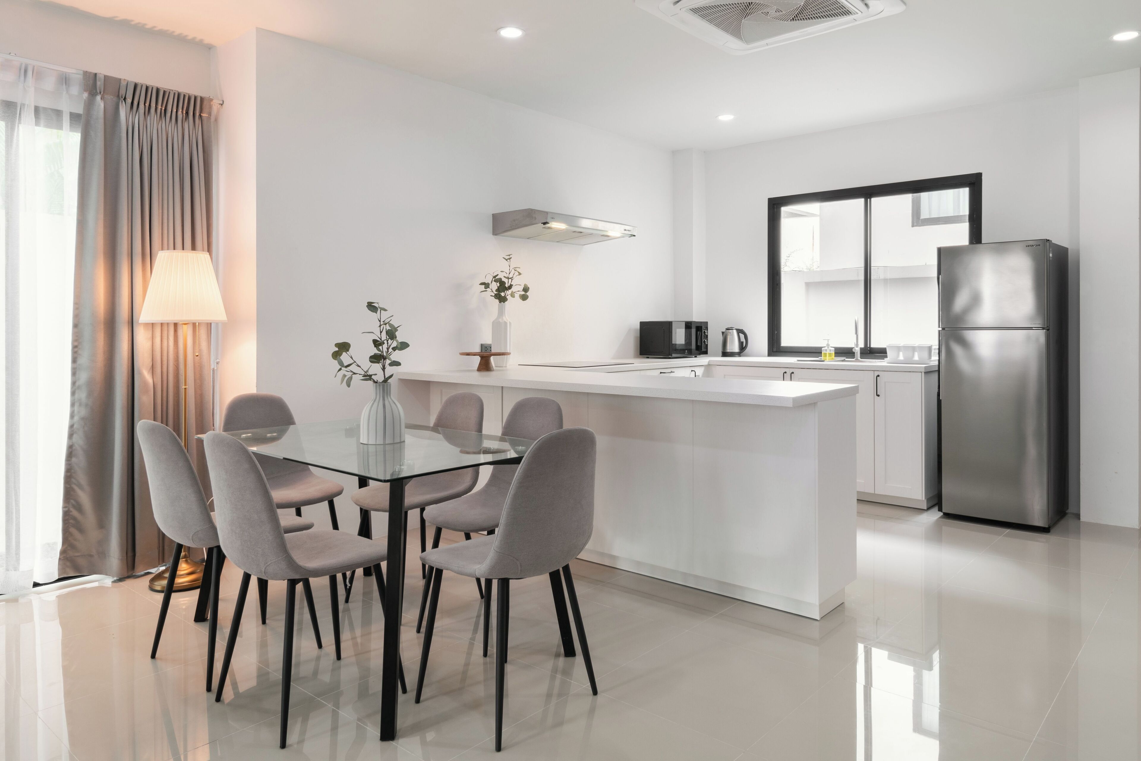 A modern kitchen with a central island, a refrigerator, and a microwave.