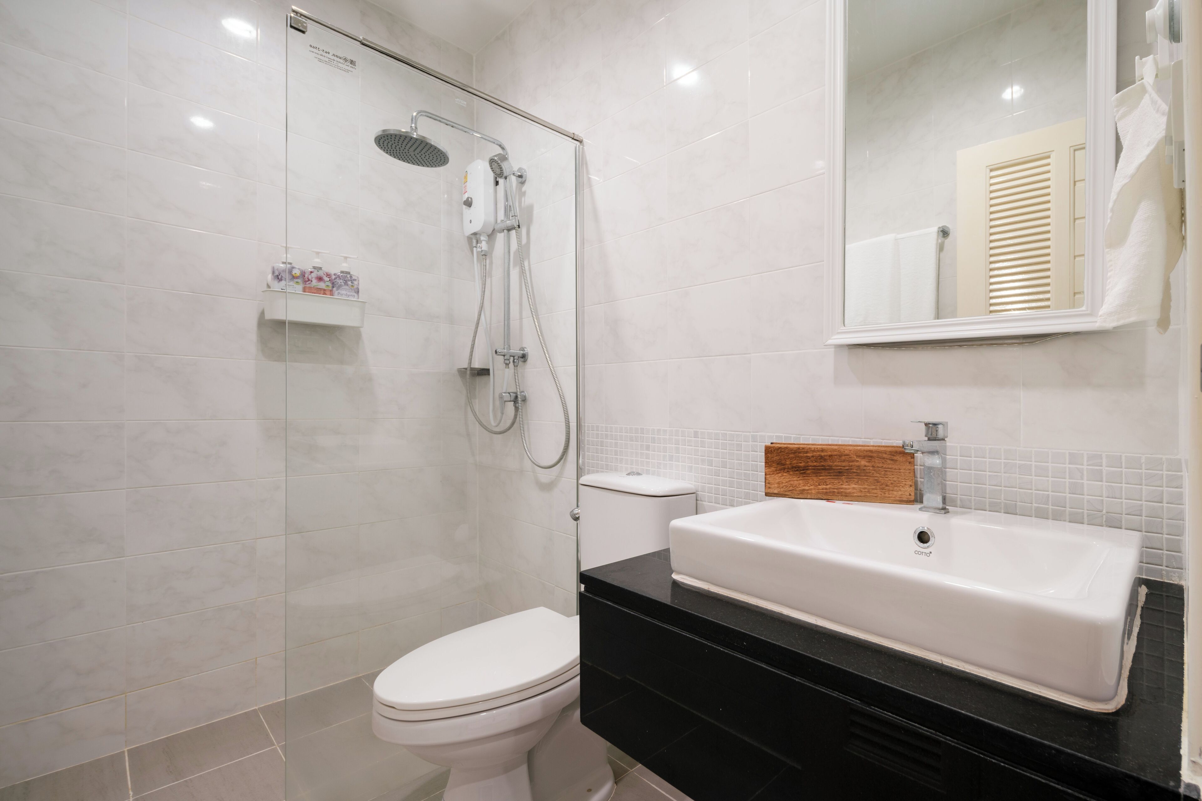 A bathroom with a shower, toilet, and sink.