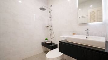 A modern bathroom with a toilet, sink, and shower.
