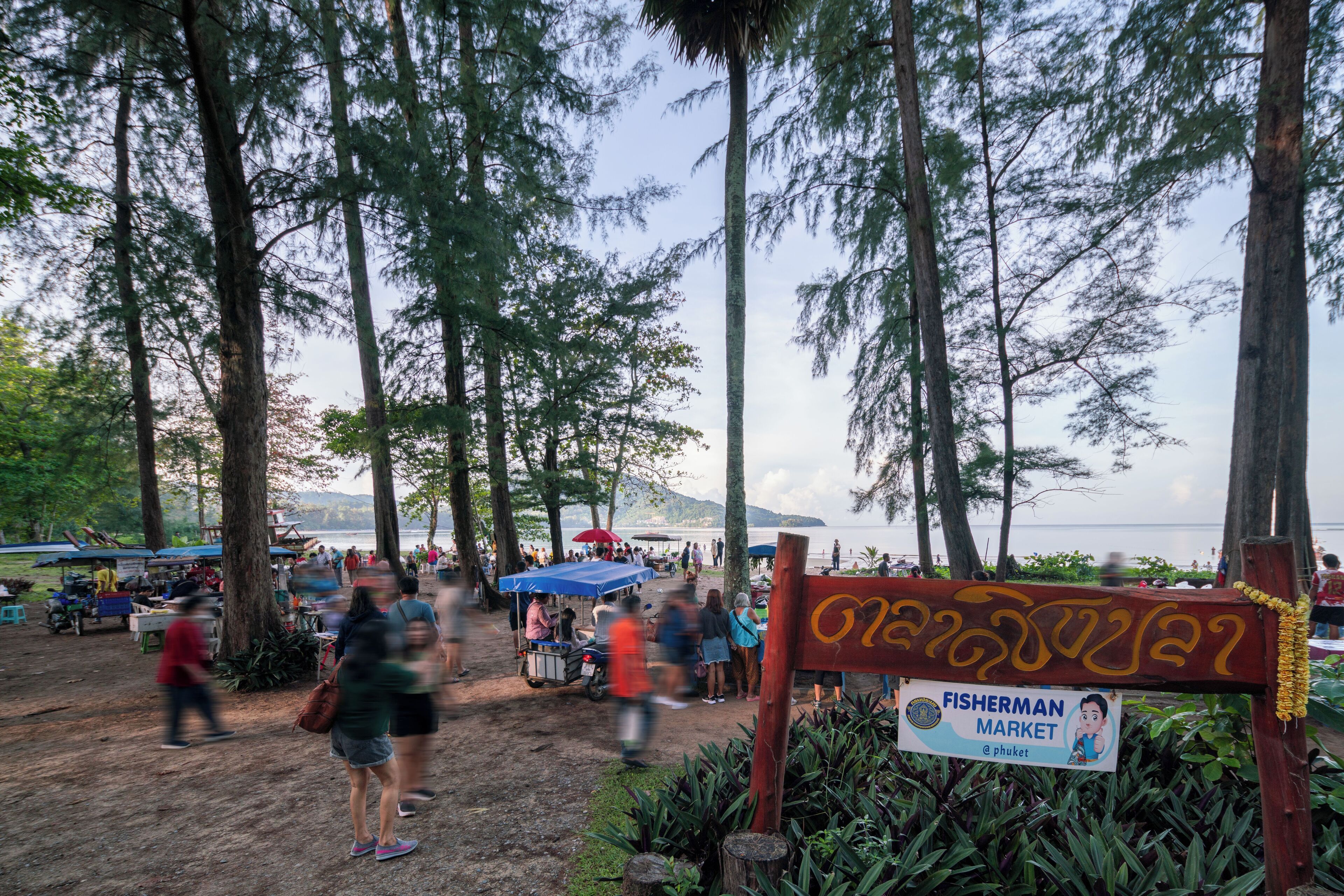 Un marché animé en plein air, avec une enseigne indiquant « Marché aux poissons ».