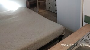 Un dormitorio con cama, cómoda, un globo terráqueo y un baño visible a través de una puerta abierta.