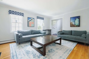 A living room with two grey sofas, a wooden coffee table, and a patterned rug.