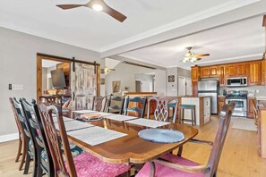 A spacious dining area with a wooden table and chairs, a ceiling fan, and a kitchen in the background. - Sleeps 14, Game Room,Movie Theater,Dock +MORE (Eatonton)