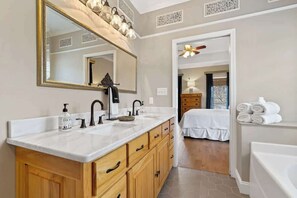 A bathroom with a large mirror, dual sinks, wooden cabinets, and a ceiling fan. - Sleeps 14, Game Room,Movie Theater,Dock +MORE (Eatonton)