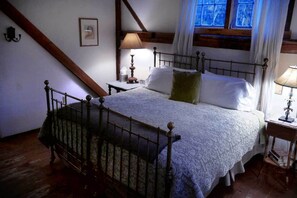 A bedroom with a four-poster bed, a nightstand, a lamp, a framed picture on the wall, and a window with curtains. - Race Brook Lodge  (Sheffield)