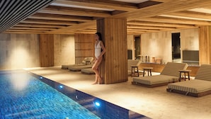 A modern indoor pool area with wooden beams, lounge chairs, and a person standing by the pool.
