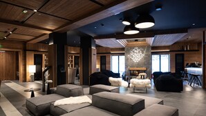 A modern lounge area with sofas, a fireplace, and a bar area.
