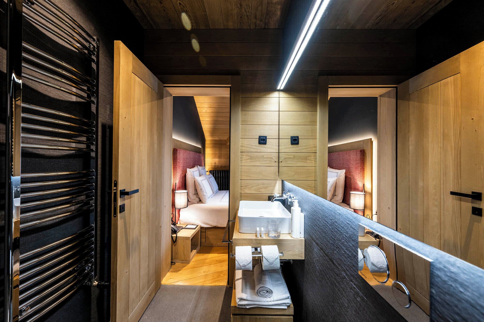 Un baño moderno y funcional con muebles de madera, un lavamanos central y un espejo.