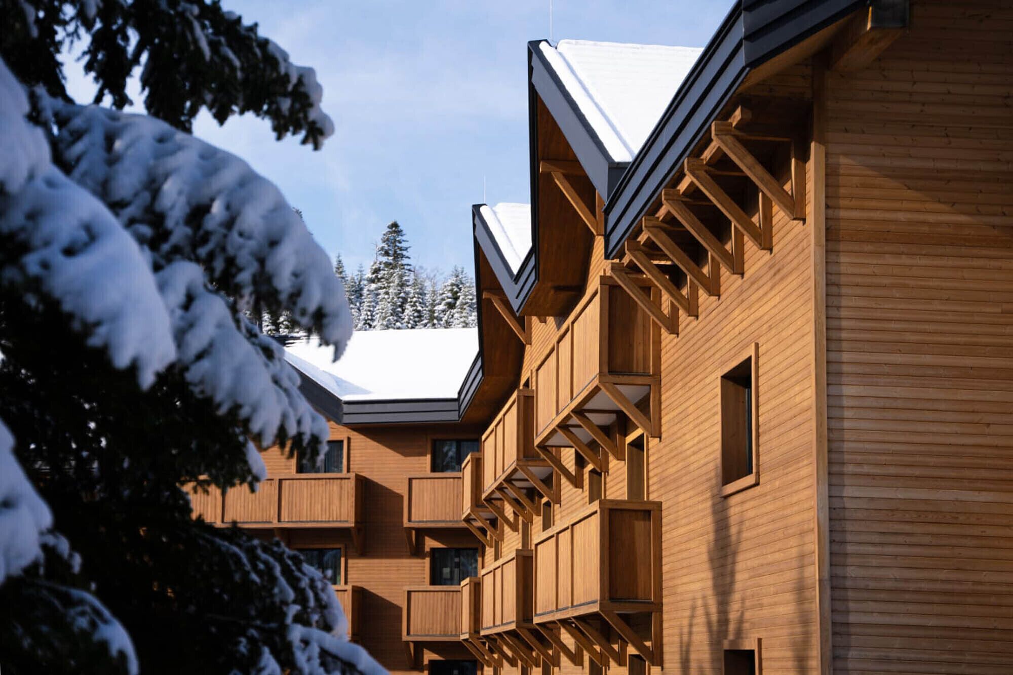A wooden building with multiple balconies and a sloped roof.