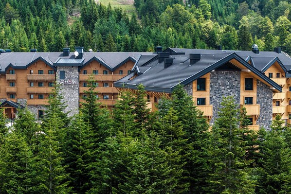 A hotel with multiple floors, balconies, and a stone facade. - Swissôtel Resort Kolasin (Vranjak)