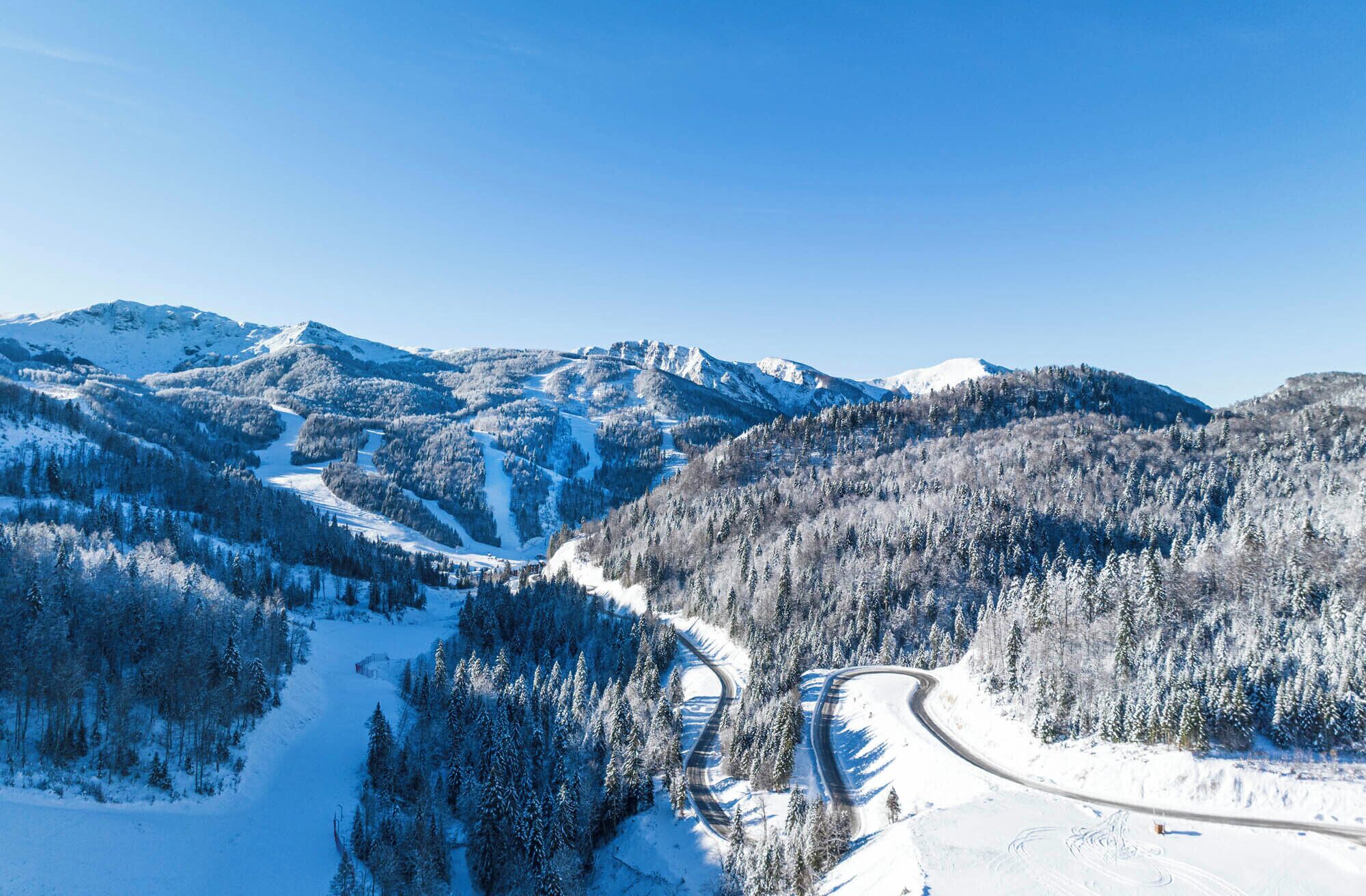 A snow-covered mountain landscape with a winding road.