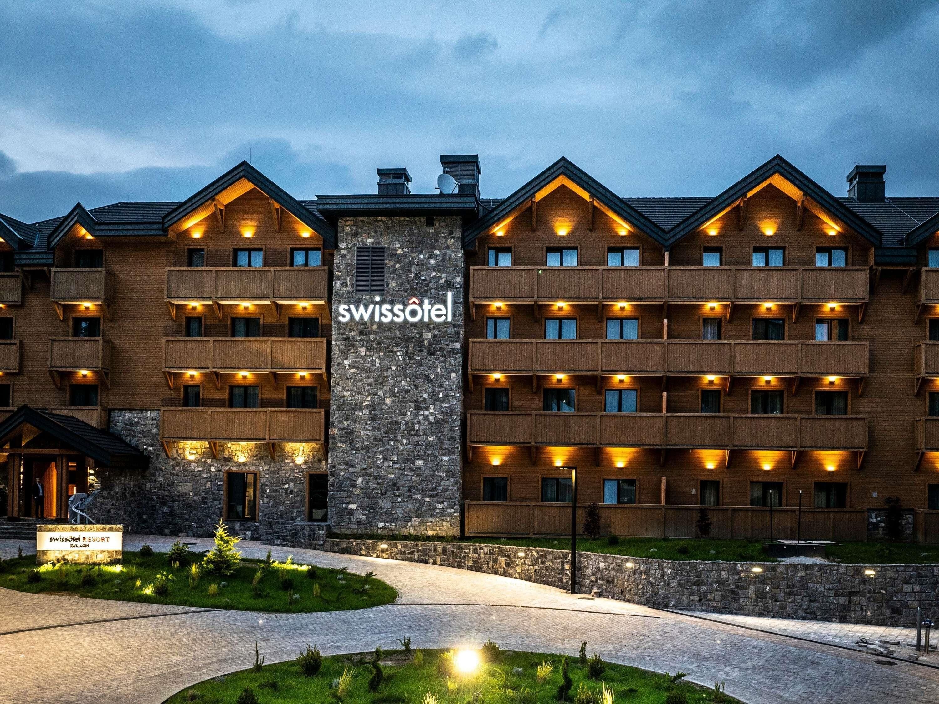 Ein Hotel mit mehreren Balkonen, einer Stein-Fassade und einem Schild, das anzeigt, dass es sich um ein Swissotel handelt.
