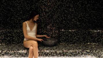 Guests can unwind in a serene space with a large, round basin and mosaic tile floor.