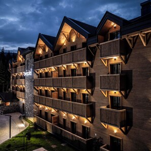 A multi-story hotel with wooden balconies and a stone pillar. - Swissôtel Resort Kolasin (Vranjak)