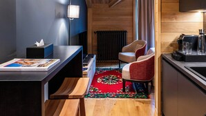 A compact, modern kitchen with wooden cabinetry, a built-in bench, and a small dining area.