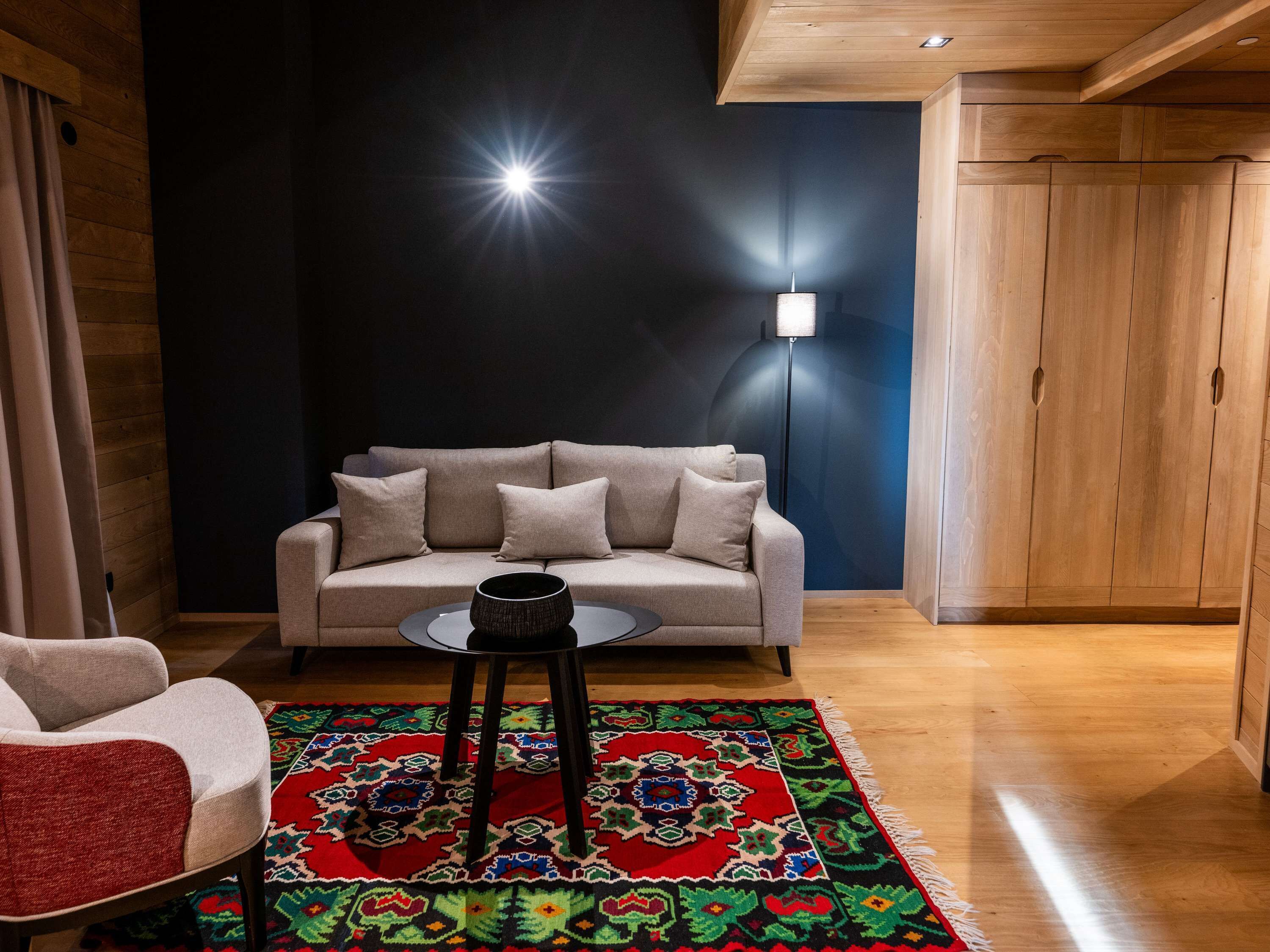 A modern living room with a sofa, a coffee table, and a patterned rug.