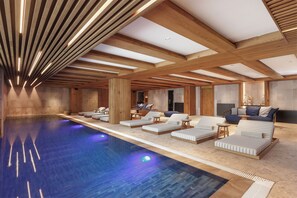 A modern indoor pool area with lounge chairs and a wooden ceiling structure. - Swissôtel Resort Kolasin (Vranjak)