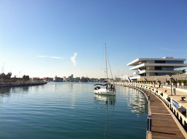 A marina with a modern building, calm water, and a dock.