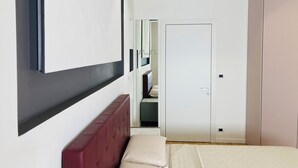 Un dormitorio con cama, armario y espejo.