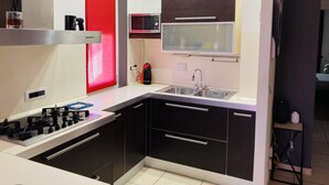 Una cocina moderna con gabinetes negros, un fregadero de acero inoxidable, un microondas y una estufa a gas.