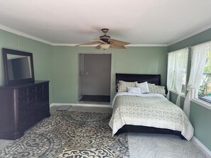 Cozy retreat with a comfortable bed, dresser, and patterned rug.