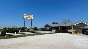 A motel with a sign reading "ROYAL REST MOTEL" and a white fence in front. - Royal Rest Motel  (Chariton)