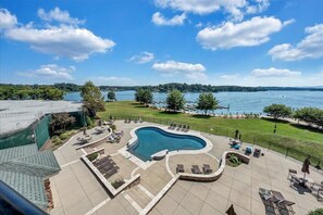 Une piscine avec des chaises longues et vue sur un lac.