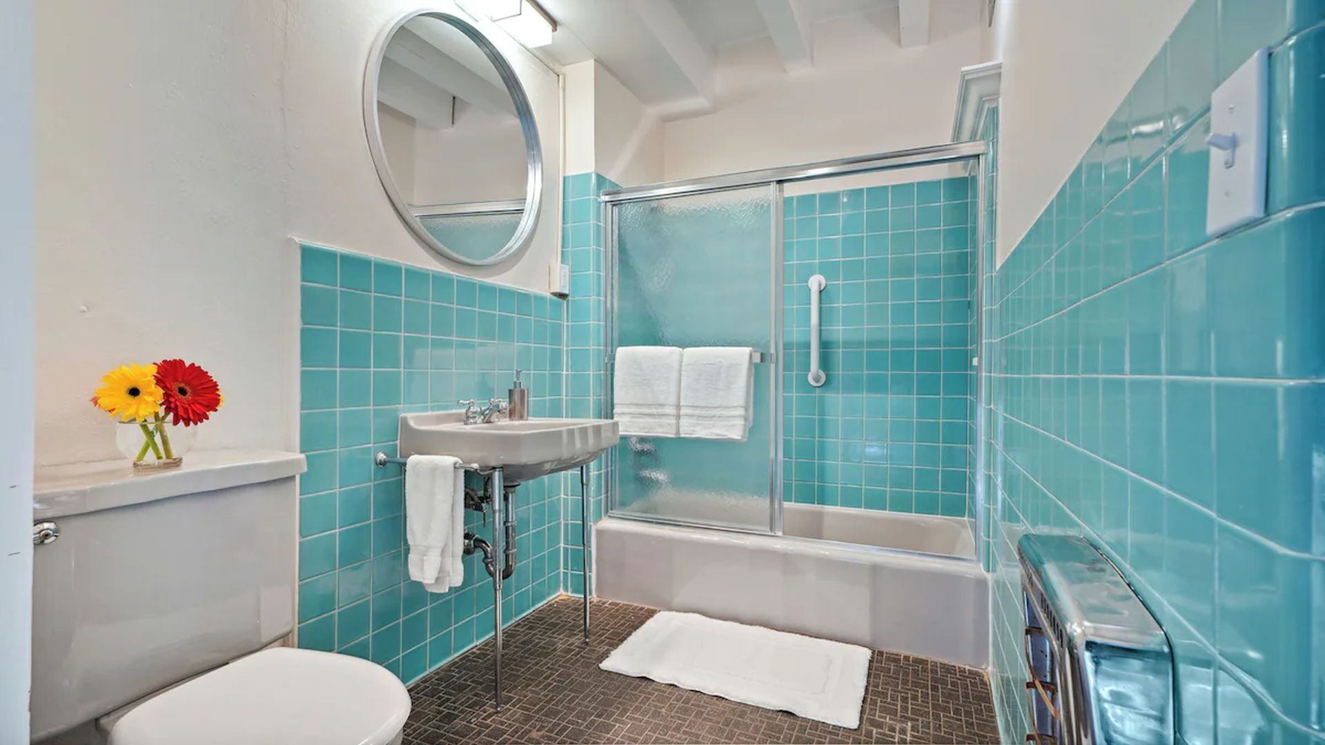 A bathroom with a toilet, sink, and shower.