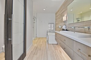 A modern bathroom with a large mirror, a bathtub, and a shower. - Parkite on Main (Park City)